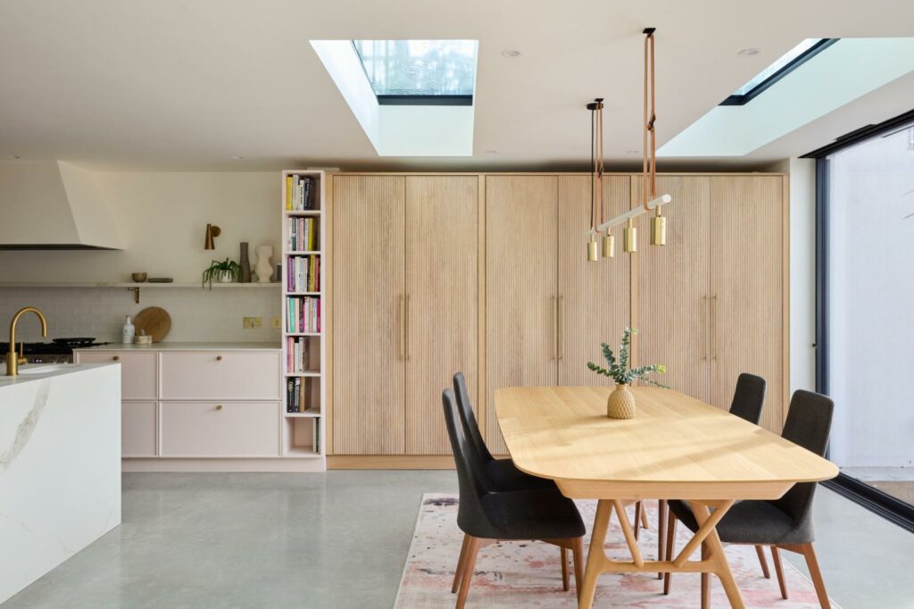 Open-plan kitchen and dining area with skylight and timber cabinetry