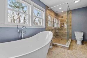 Cost of Renovation of Bathroom featuring a modern bathroom with freestanding bathtub, walk-in glass shower, tiled flooring, and contemporary fixtures in a UK home