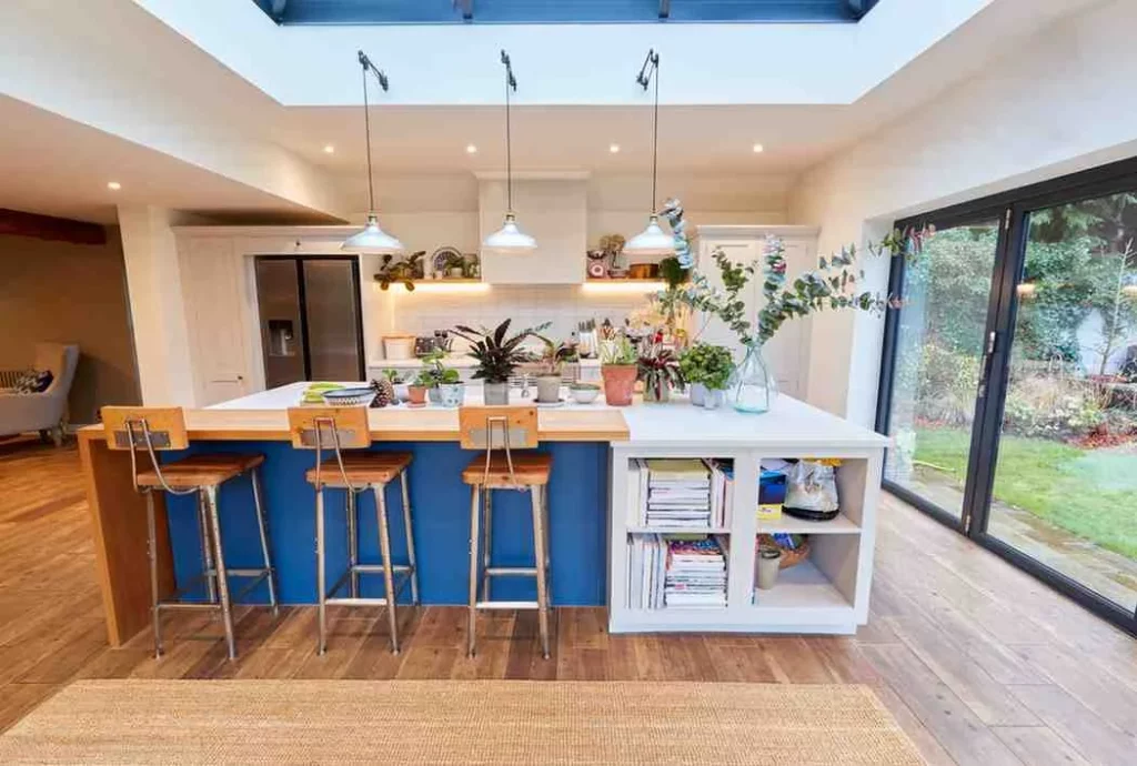 Kitchen Extension Ideas with blue kitchen island, roof lantern, open plan kitchen, natural light, breakfast bar, and large sliding doors overlooking the garden