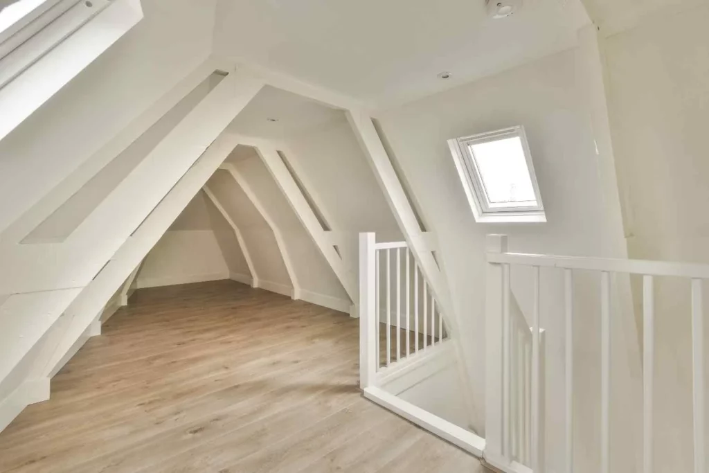 L Shaped Loft Conversion interior with exposed beams, roof windows, modern flooring, and additional living space in a Victorian terrace home