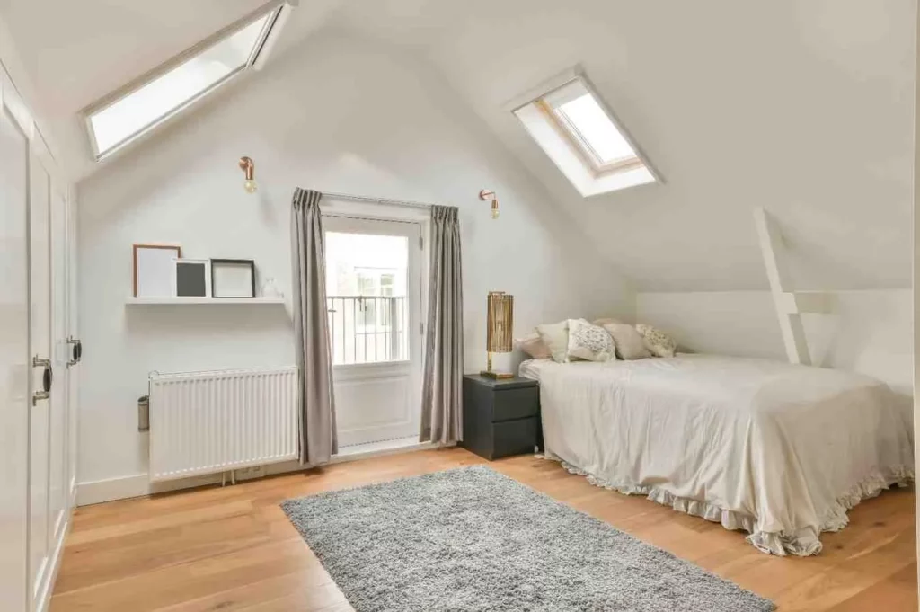 Types of Loft Conversion featuring a Velux Rooflight Loft Conversion bedroom with natural light, sloping roof design, and modern living space