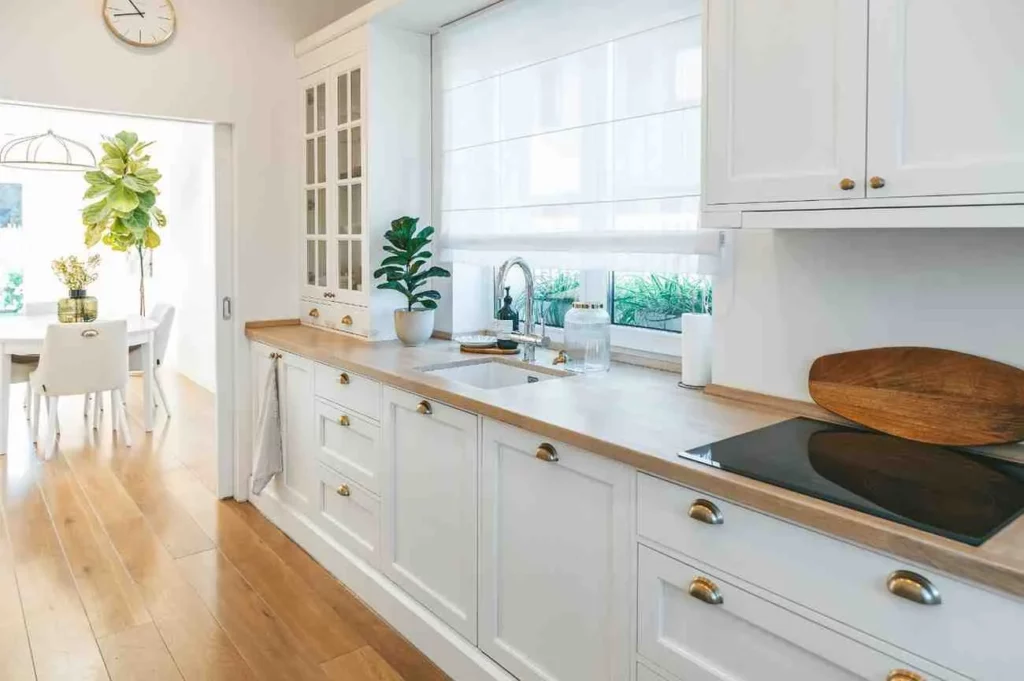 What is a Shaker Kitchen? Bright white Shaker kitchen with Shaker kitchen cabinets, Five-piece cabinet door, Recessed centre panel, Solid wood cabinetry, natural materials, and a clean timeless design.