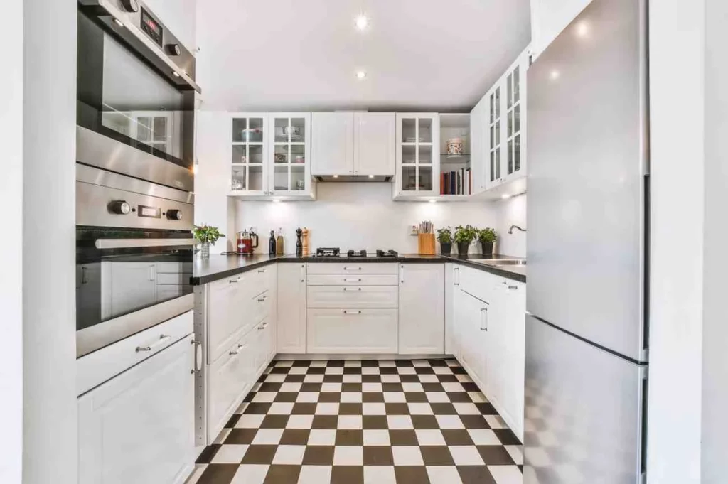 Modern U Shaped kitchen ideas featuring white shaker cabinets, black countertops, stainless steel appliances, checkerboard flooring, and smart storage for a small kitchen layout.